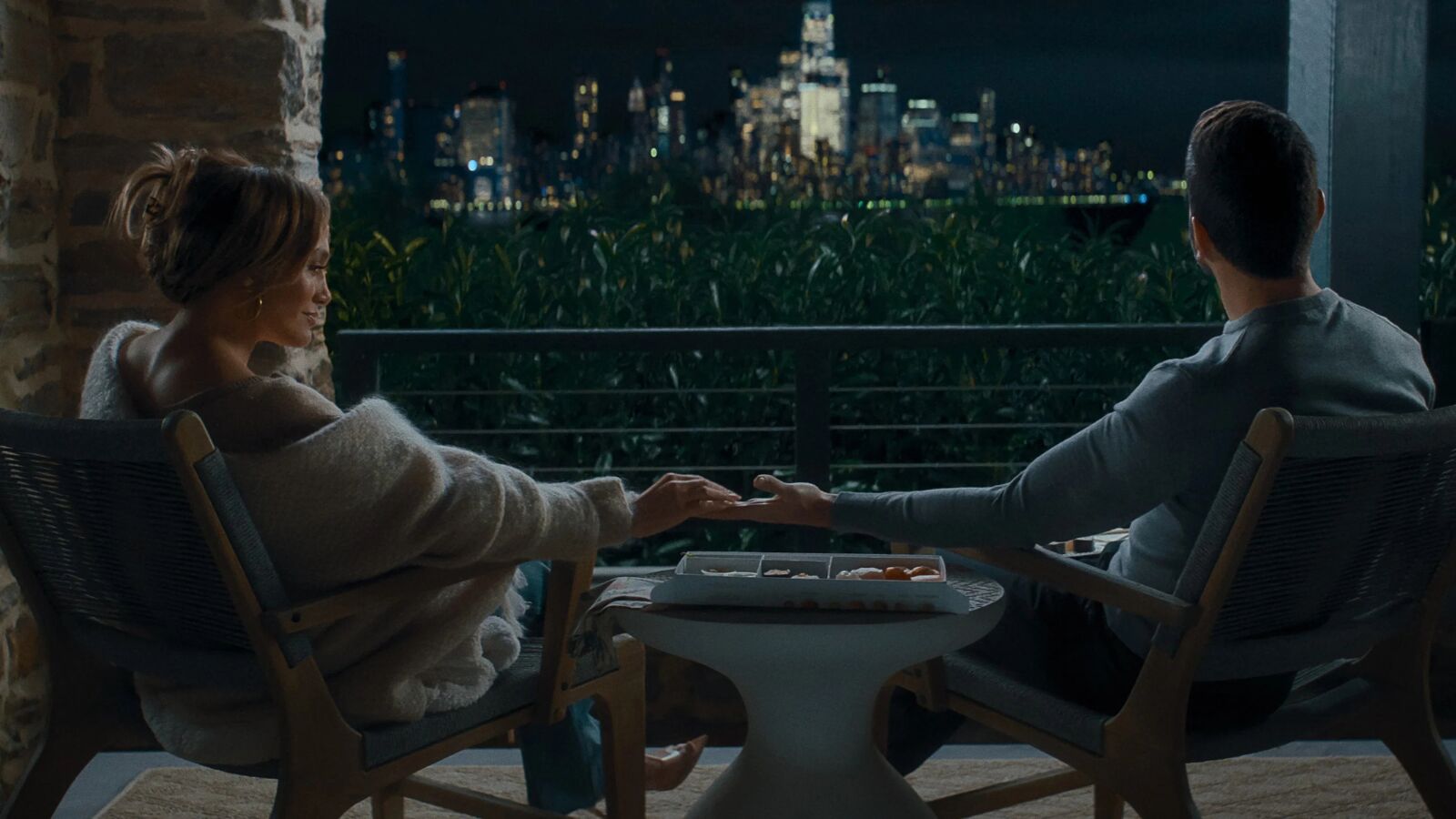 Jennifer Lopez en Brett Goldstein die elkaar hand vast hebben. 