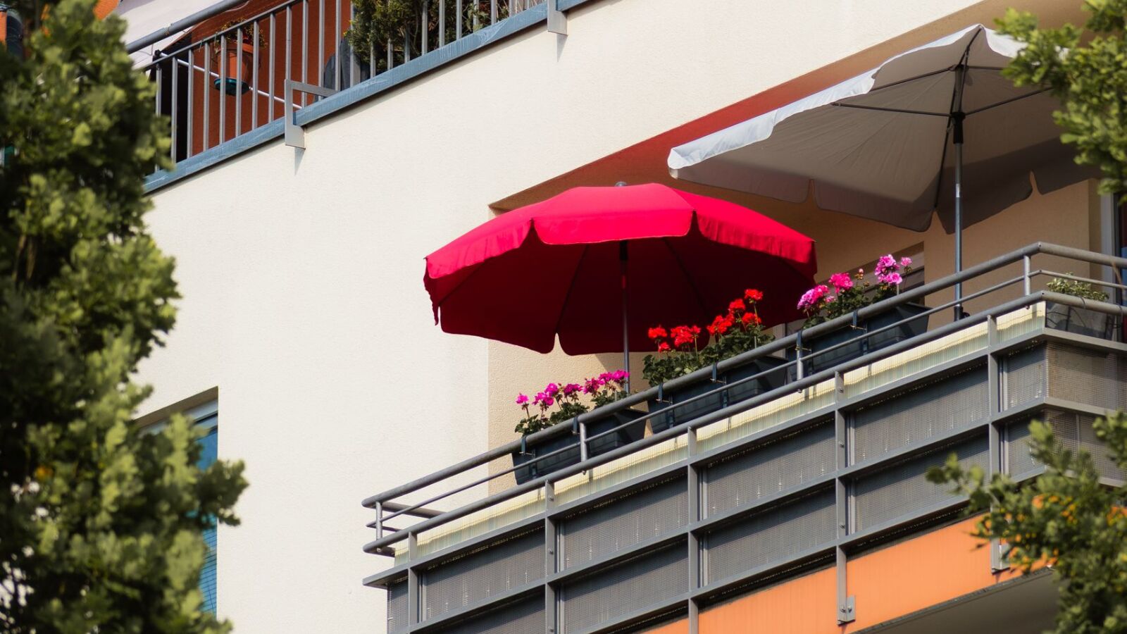 Twee parasols die uitstaan op een balkon