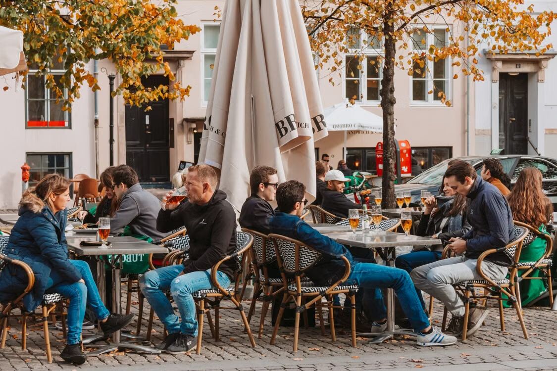 Vol terras met mensen die van hun drankje genieten.