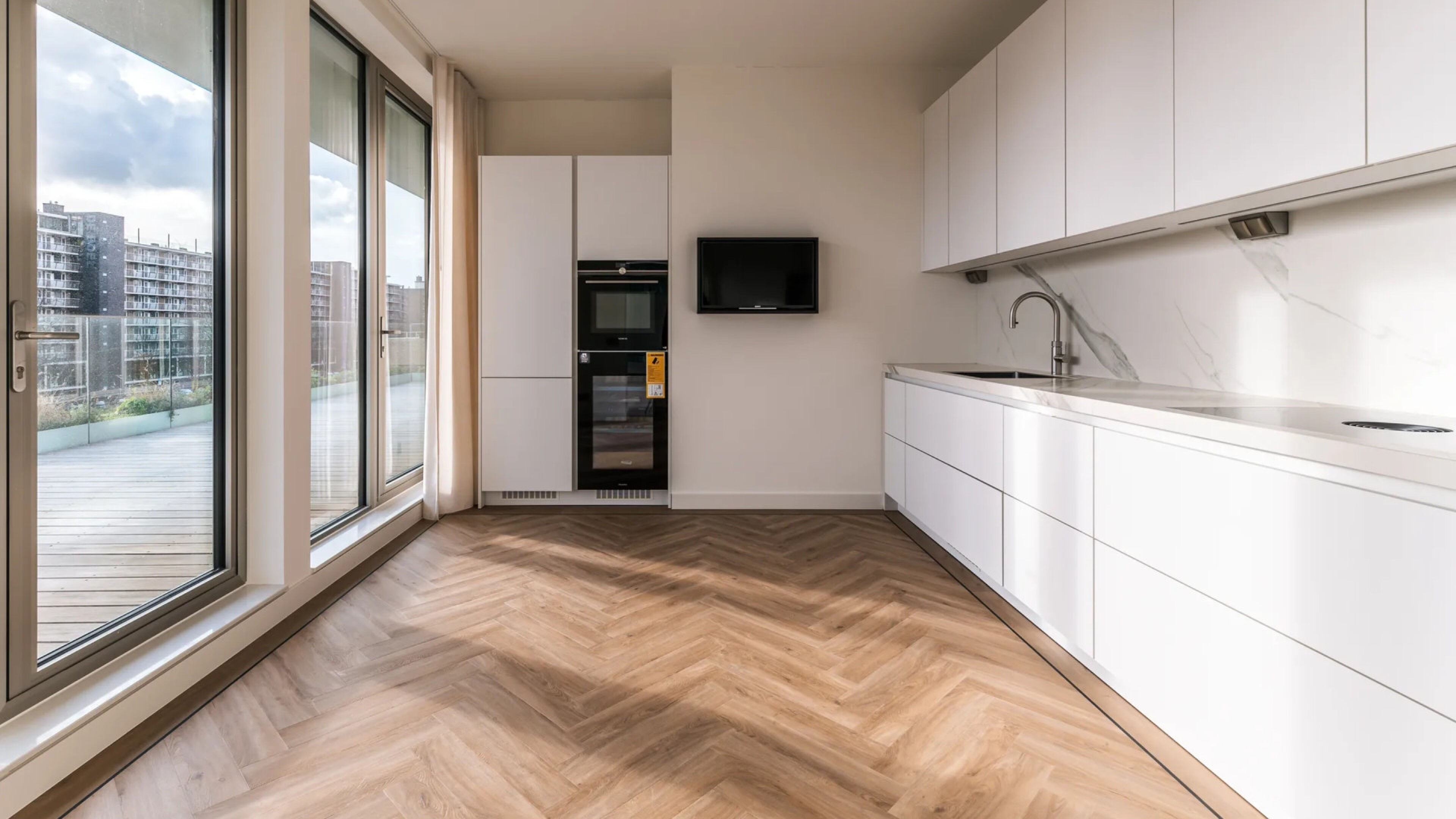 De open keuken met moderne inbouwapparatuur.