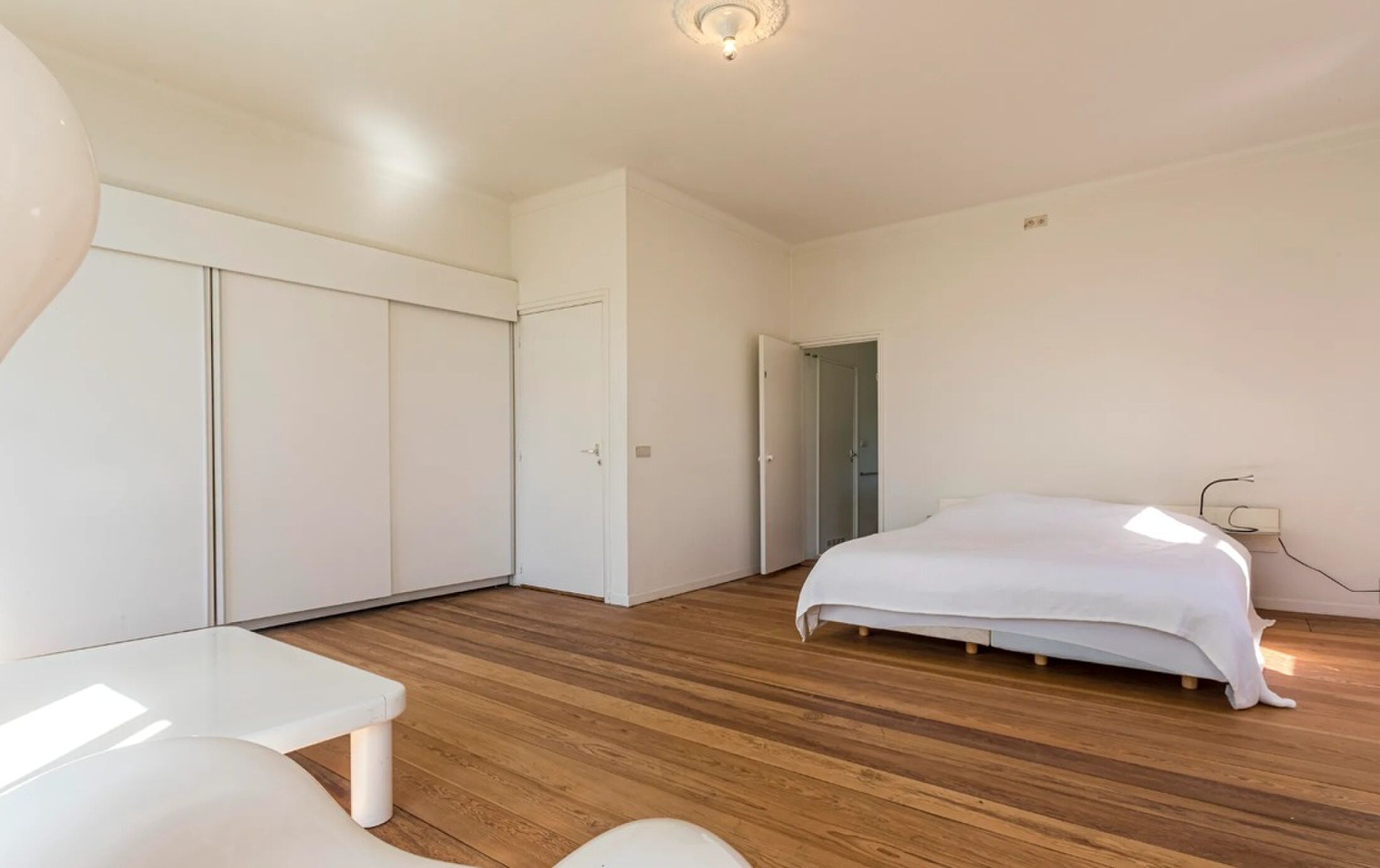 De masterbedroom met groot bed.