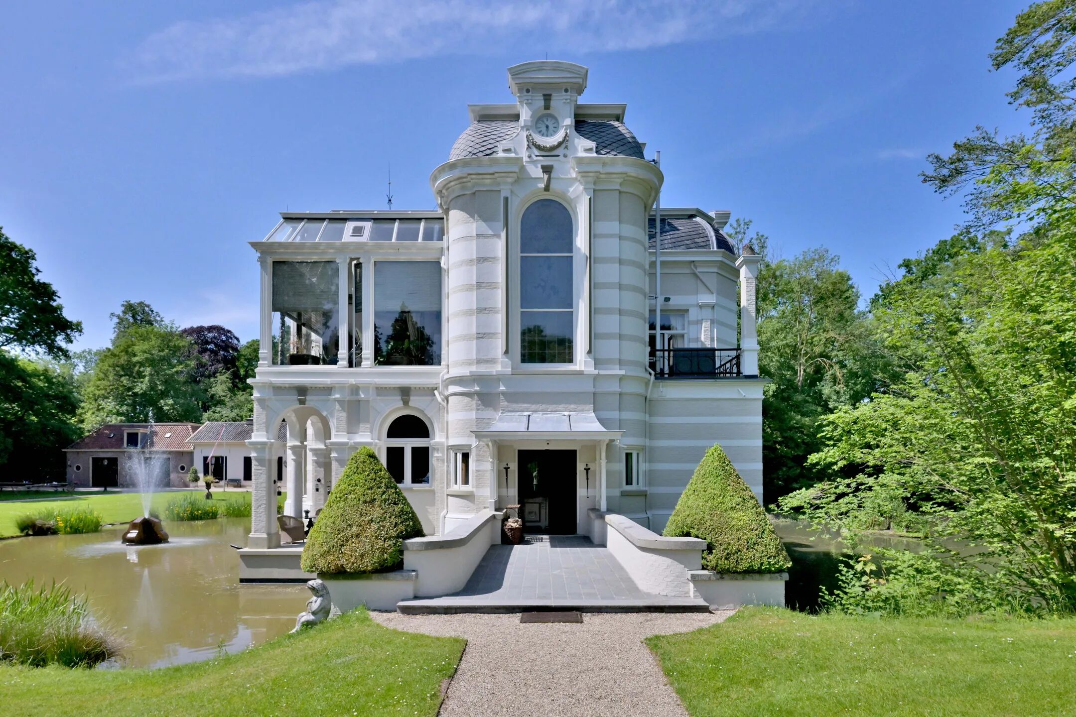 Een kasteel omringd door een tuin en water.