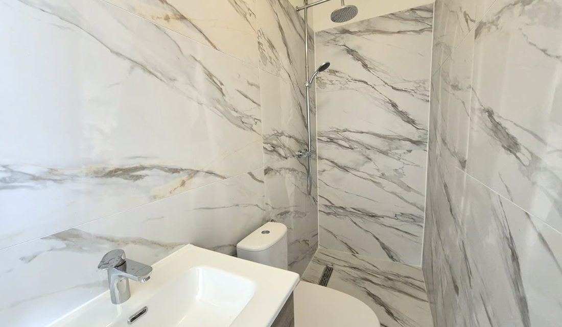 De badkamer met douche.