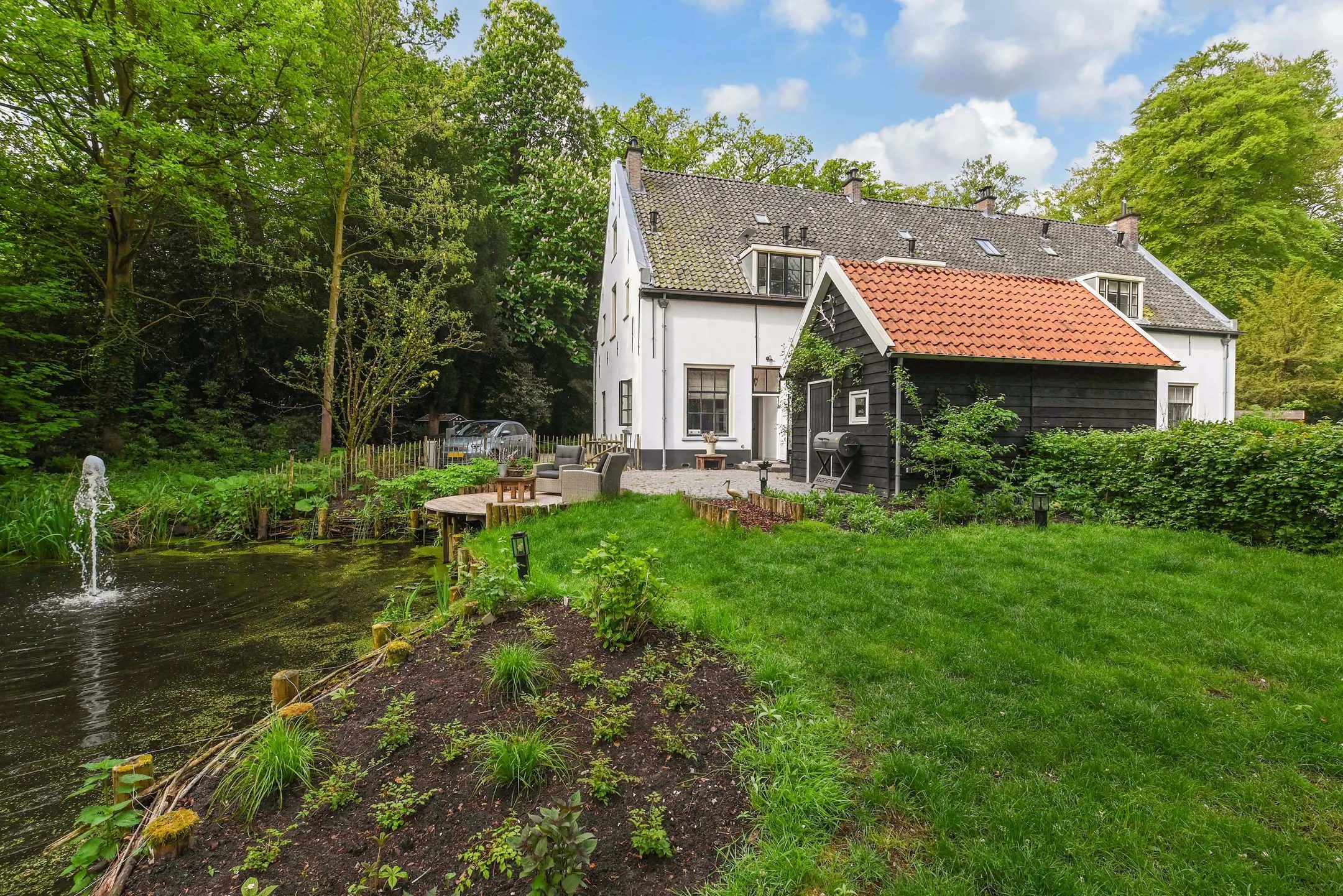 Een huis met een schuur aan het water.