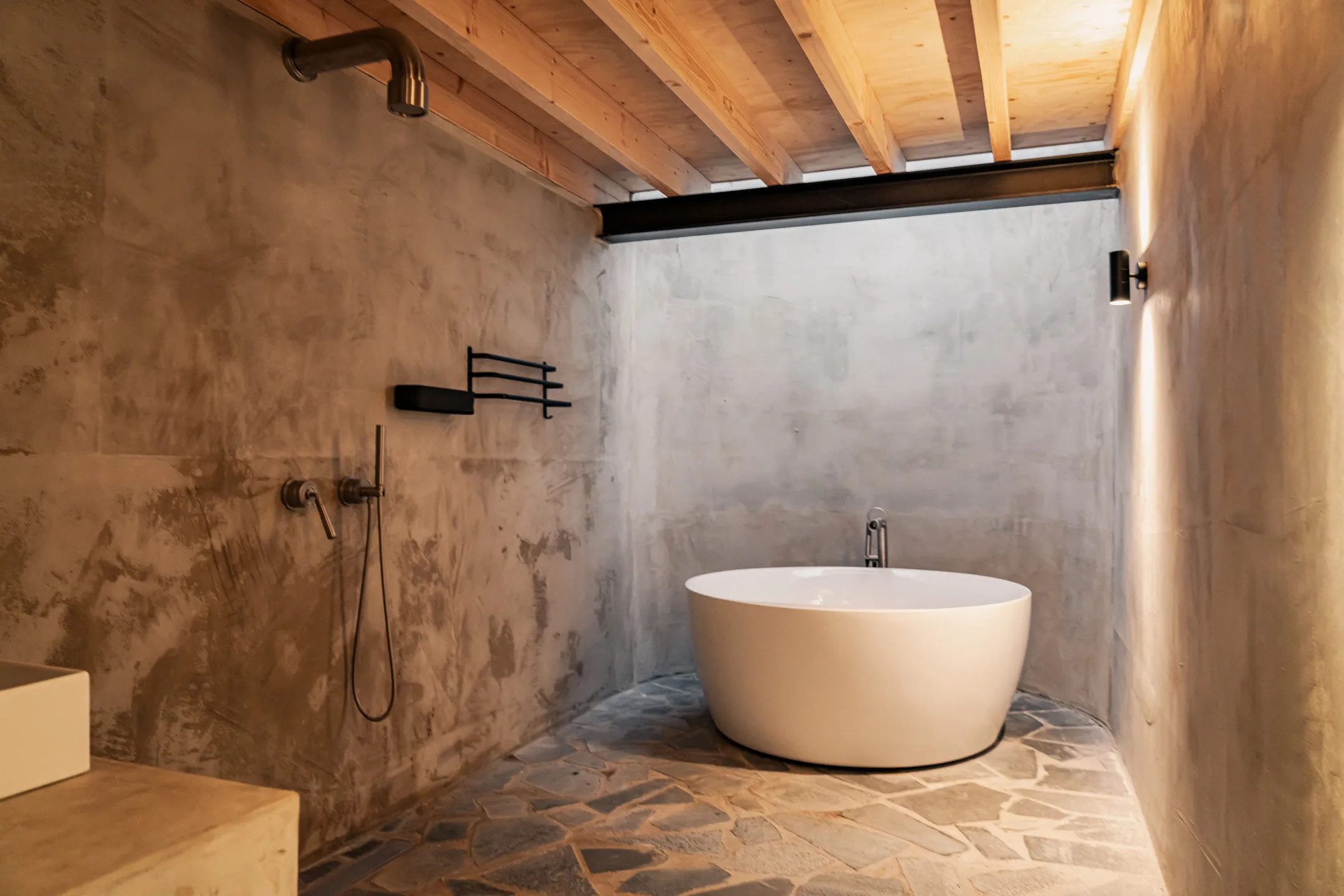 Een badkamer met douche en rond bad.