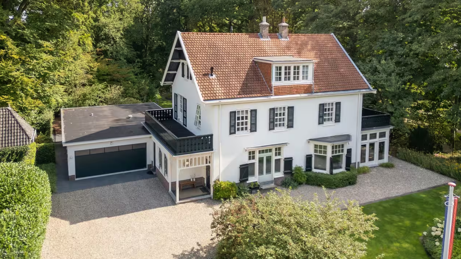 Een witte villa met een grote oprijlaan.