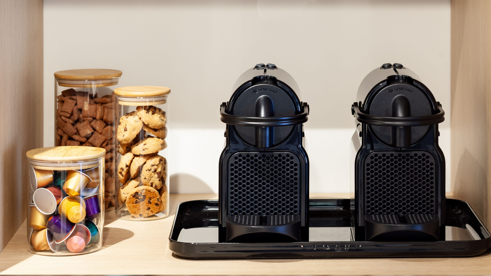 Twee koffiezetapparaten met koffiecups.