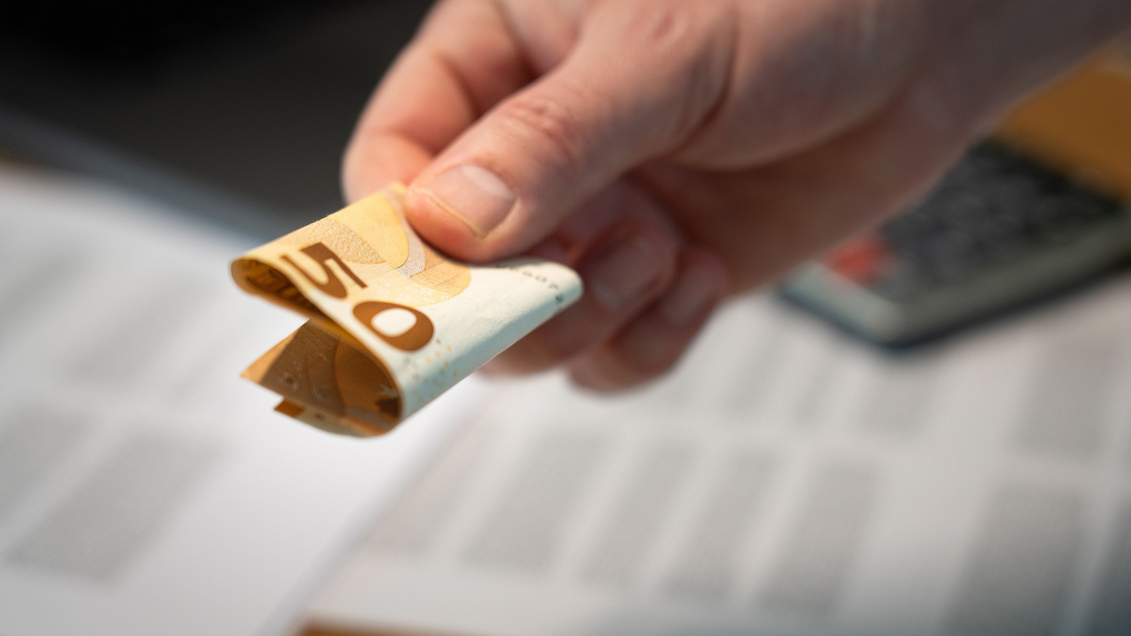 Iemand die een briefje van 50 euro geeft.