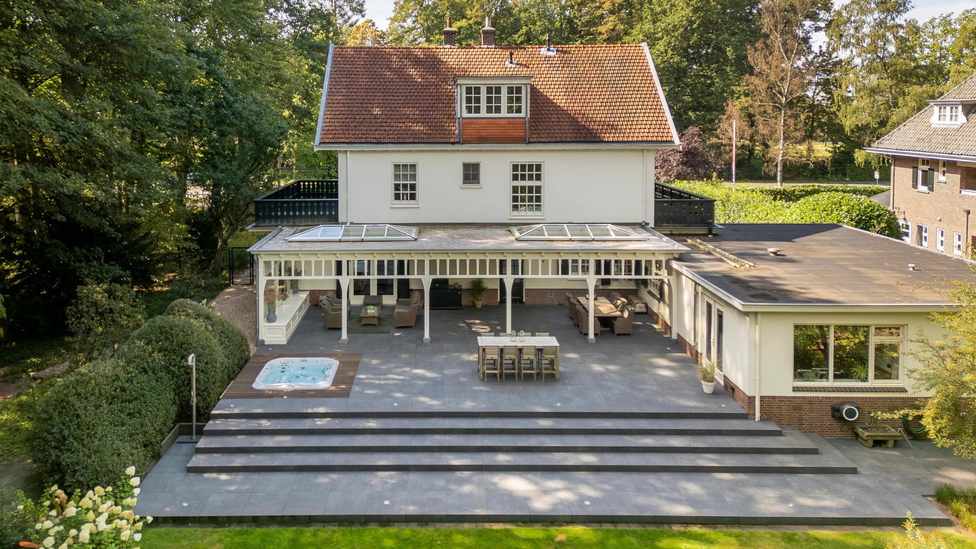 Een villa met achtertuin en jacuzzi.