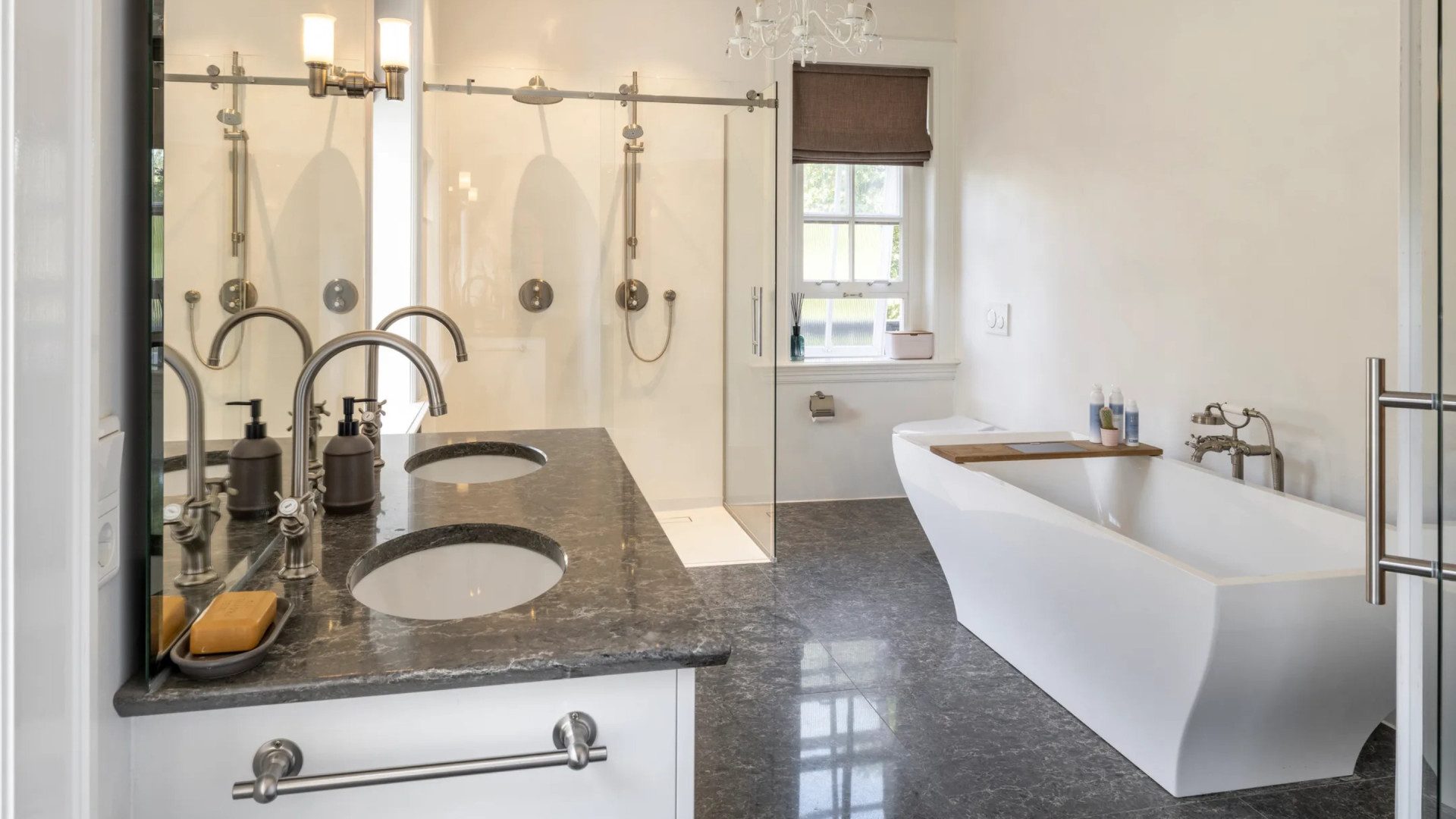 Een badkamer met twee douches en een ligbad.
