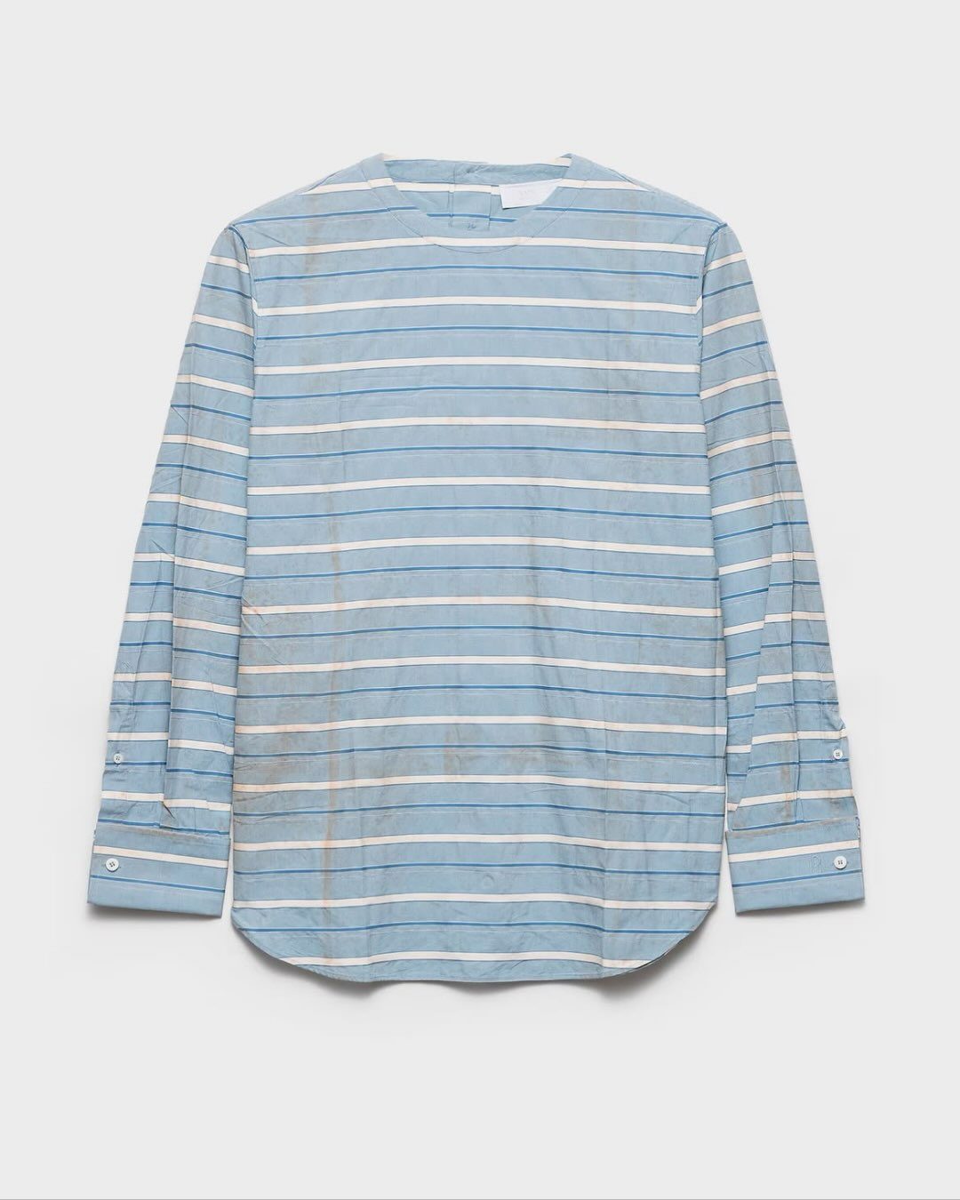 Een blauw-wit gestreept shirt met vlekken.