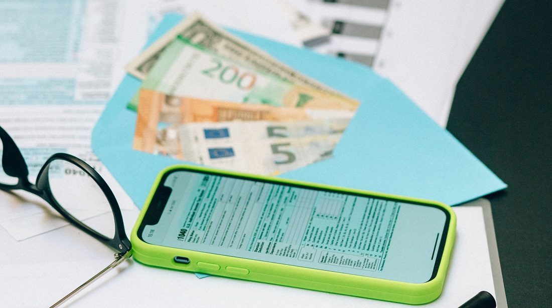 Cashgeld, een bril en een smartphone.