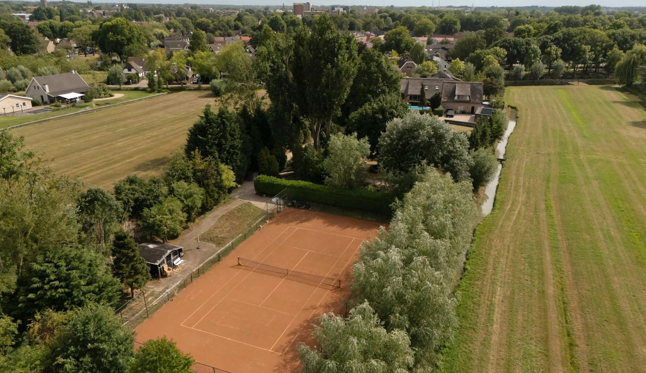 De tennisbaan van de luxe woonboerderij.
