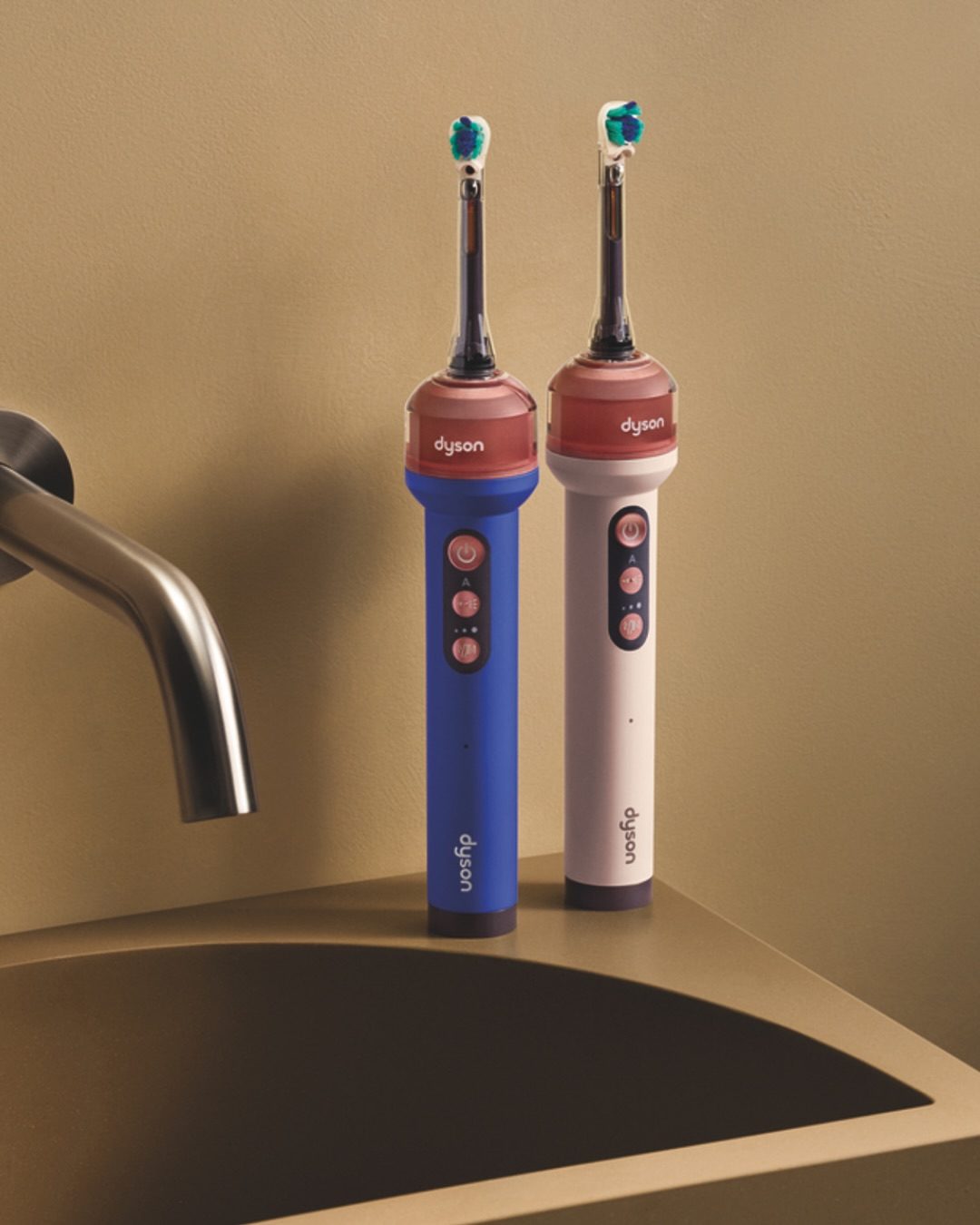 Twee Dyson tandenborstels die op de wastafel staan. 