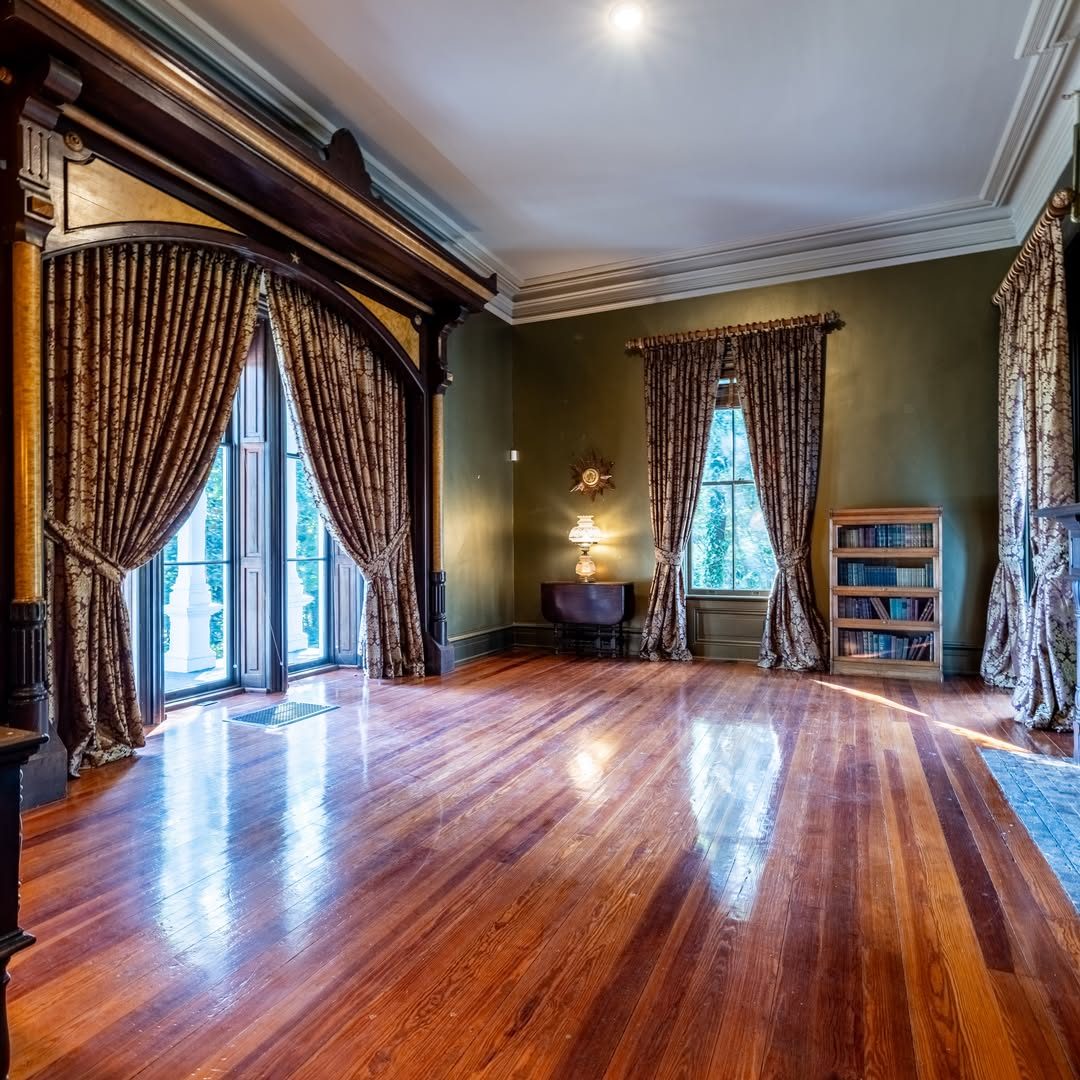 Een kamer met gordijnen en een boekenkast in het Creel House