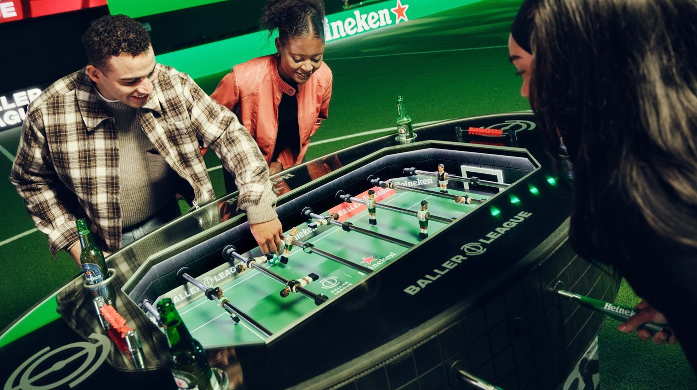Mensen die spelen met de voetbaltafel van Heineken.