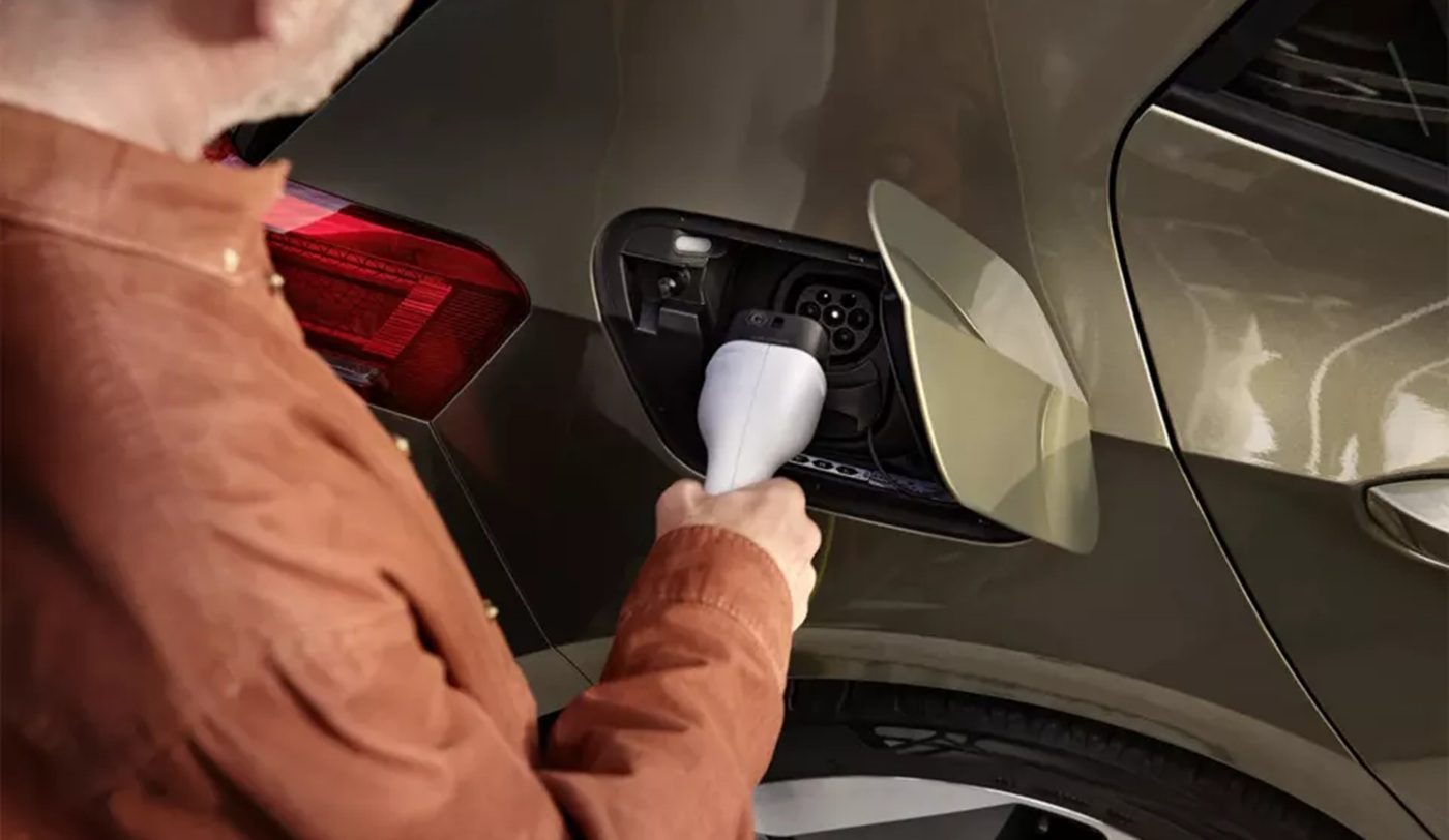 Iemand die een EV van Volkswagen probeert op te laden.