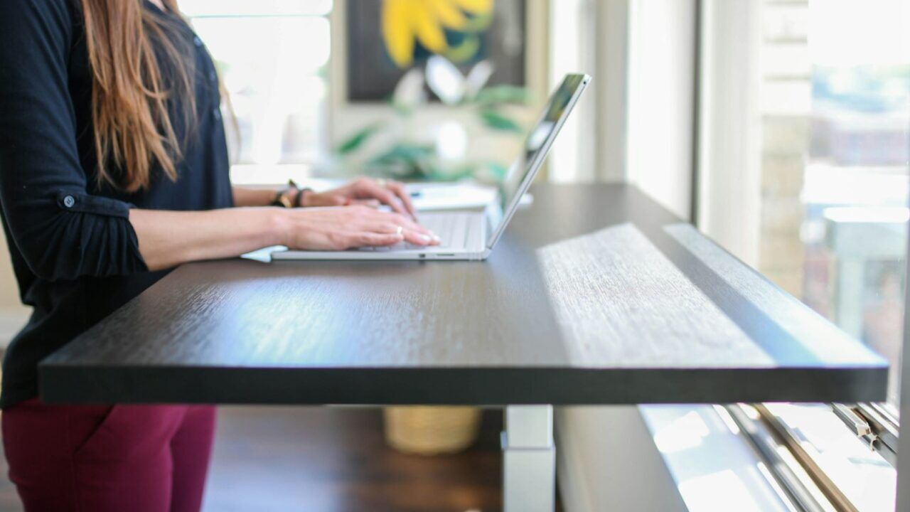 Een vrouw die aan het werken is aan een sta-bureau