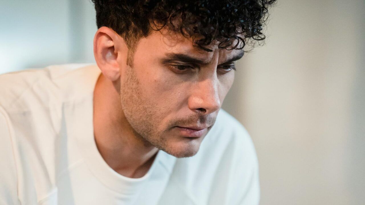 Man die zit op de bedrand en zich schuldig voelt omdat hij het stiekem doet met de moeder van zijn beste vriend