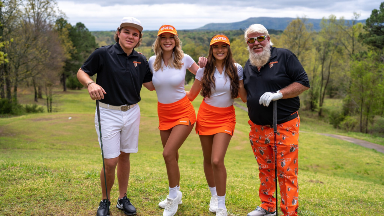 John Daly samen met zijn zoon en Hooters-serveesters op de golfbaan