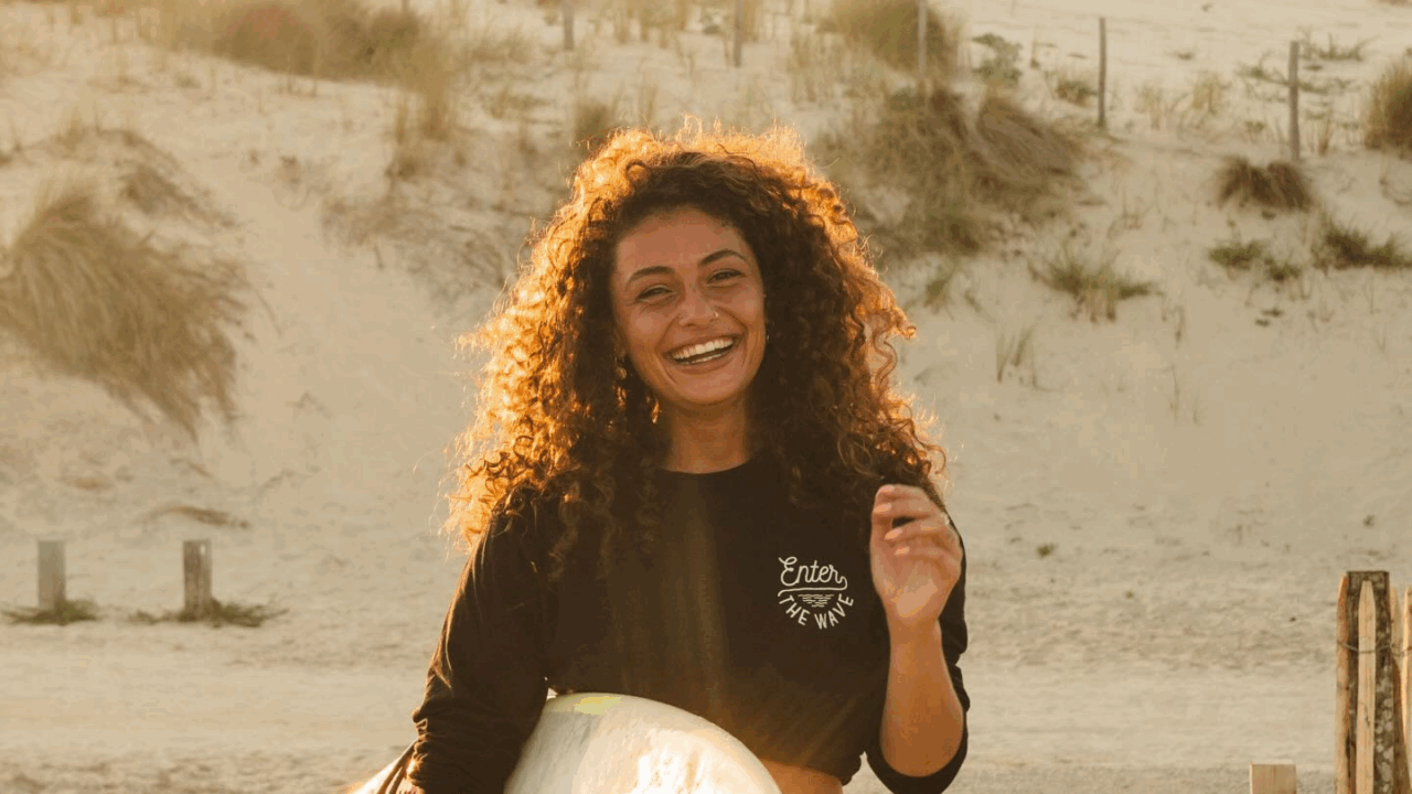 Joël van Leeuwaarde op het strand met surfbord