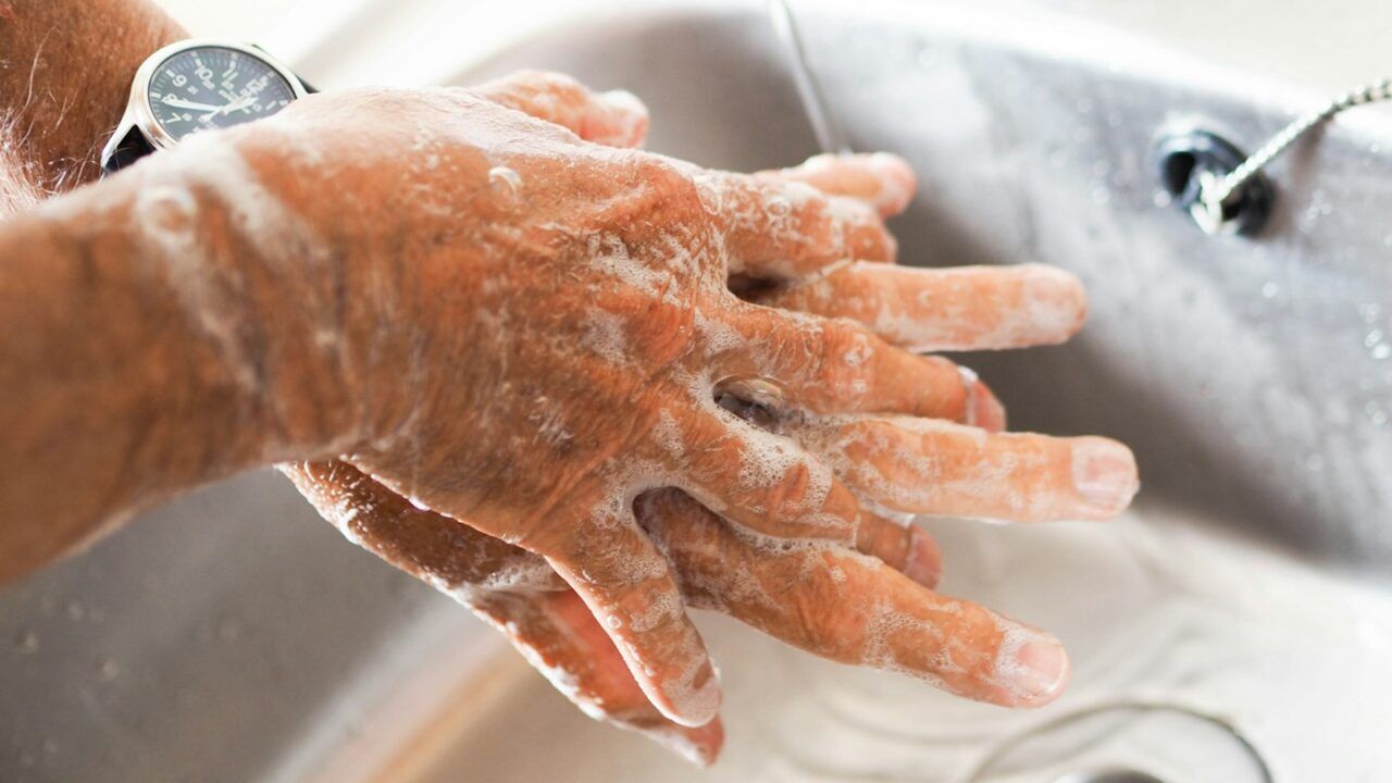 Twee mannelijke handen die gewassen worden omdat de persoon te weinig doucht