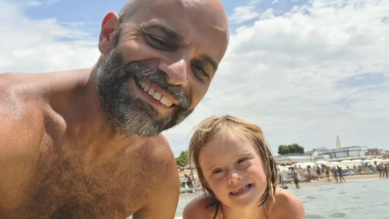 Het meisje met downsyndroom naast haar pleegvader.