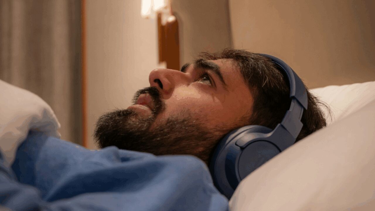 Een man die moeilijk zijn bed uitkomt in de ochtend, wat een symptoom van ADHD is