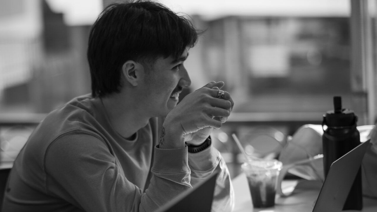 Een man die achter zijjn laptop zit voor zijn deeltijd hbo-opleiding