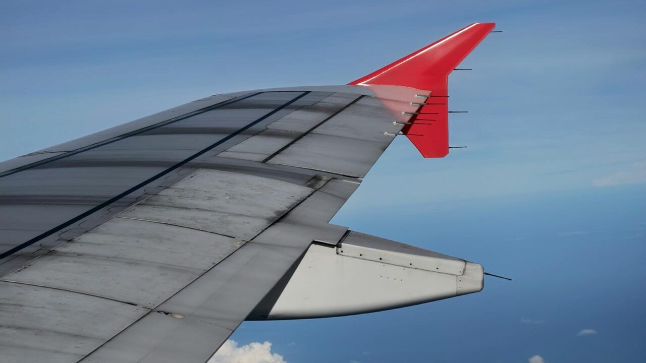 Een vleugel van een vliegtuig in de lucht