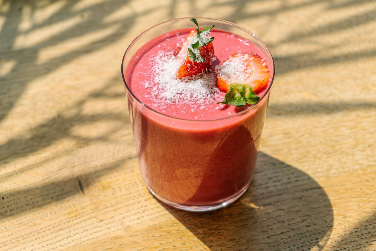 Een roze smoothie met aardbeien.