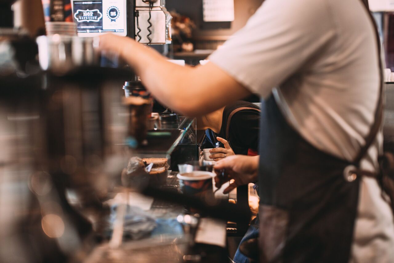 Iemand die koffie maakt met een koffiemachine.