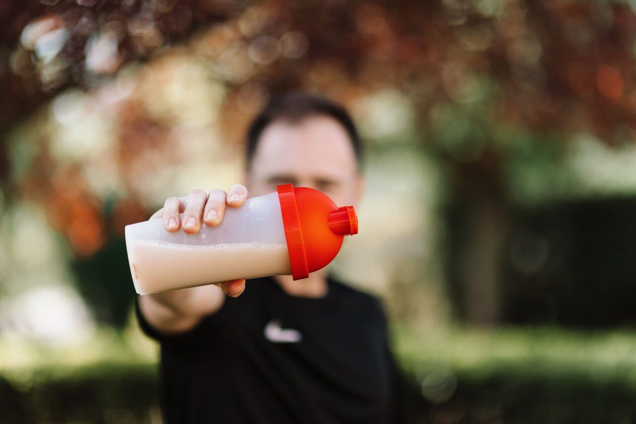Iemand met een beker pre-workout