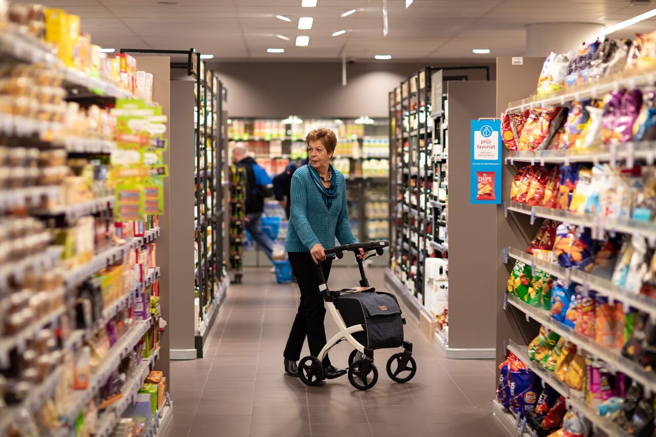 Een vrouw die in een supermarktgangpad staat