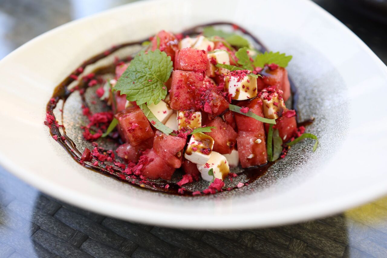 Een bakje met een watermeloensalade met feta. 