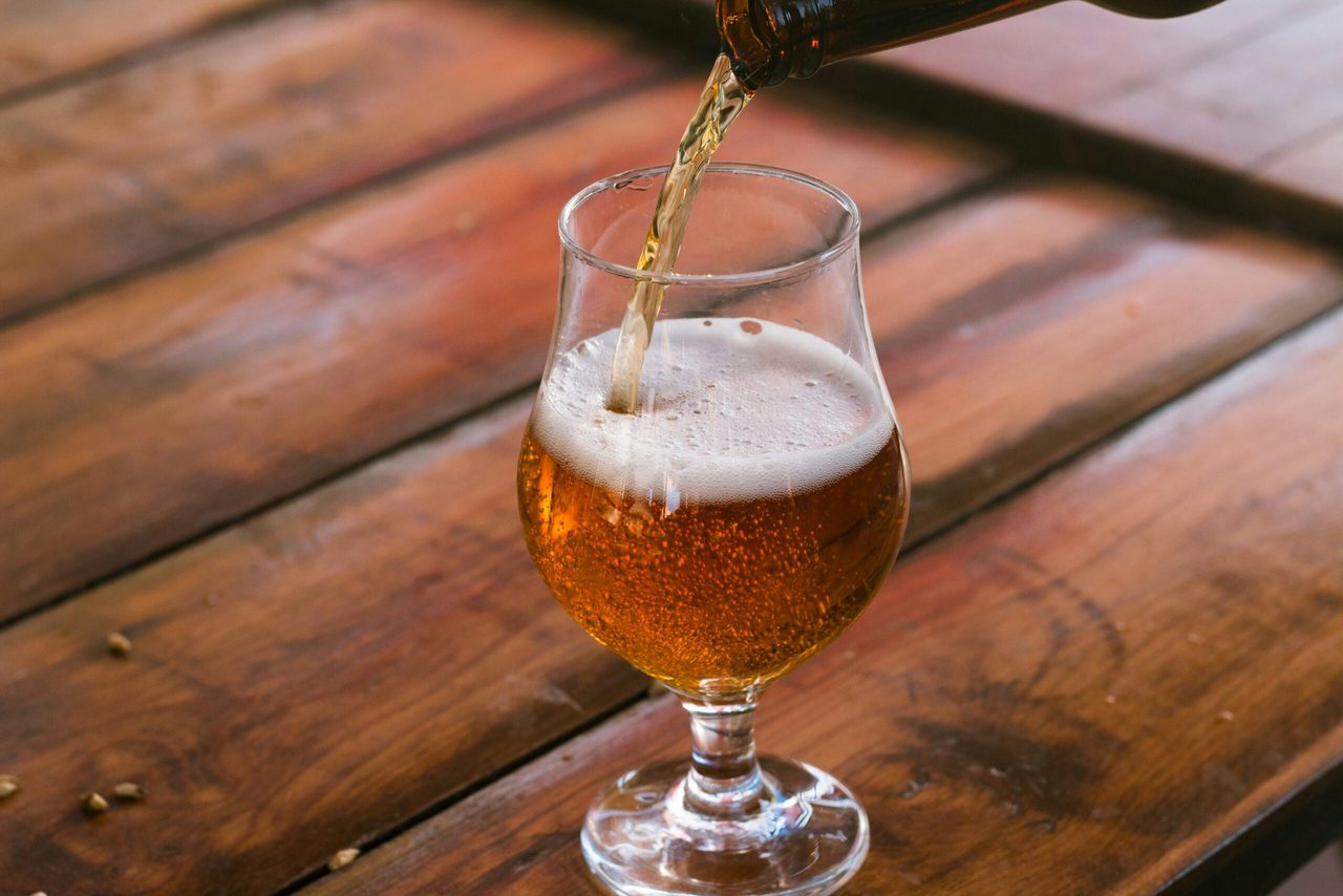 Een biertje die wordt ingeschonken in een glas.