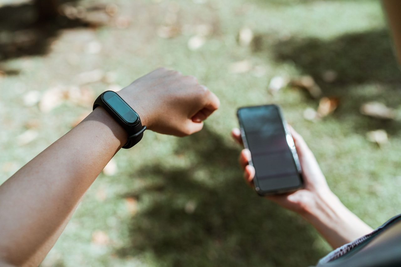 Iemand die kijkt op zijn telefoon en smartwatch.