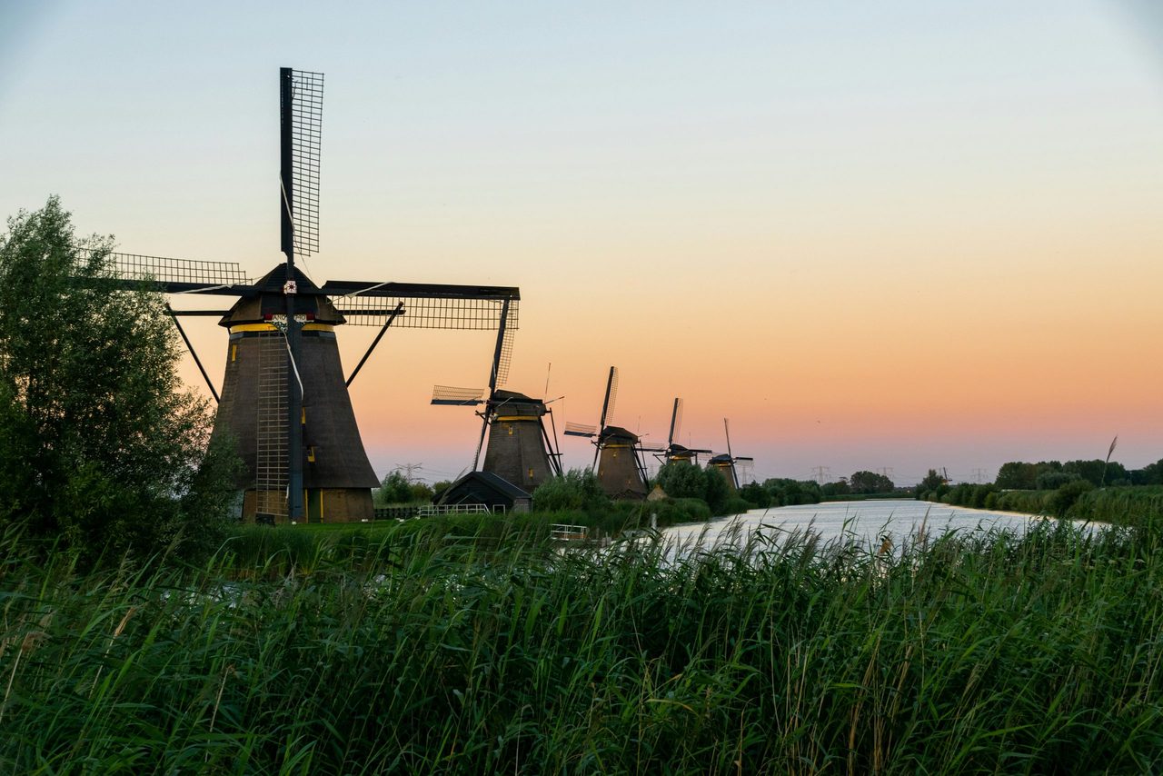 Windmolens op een rijtje met zonsondergang.