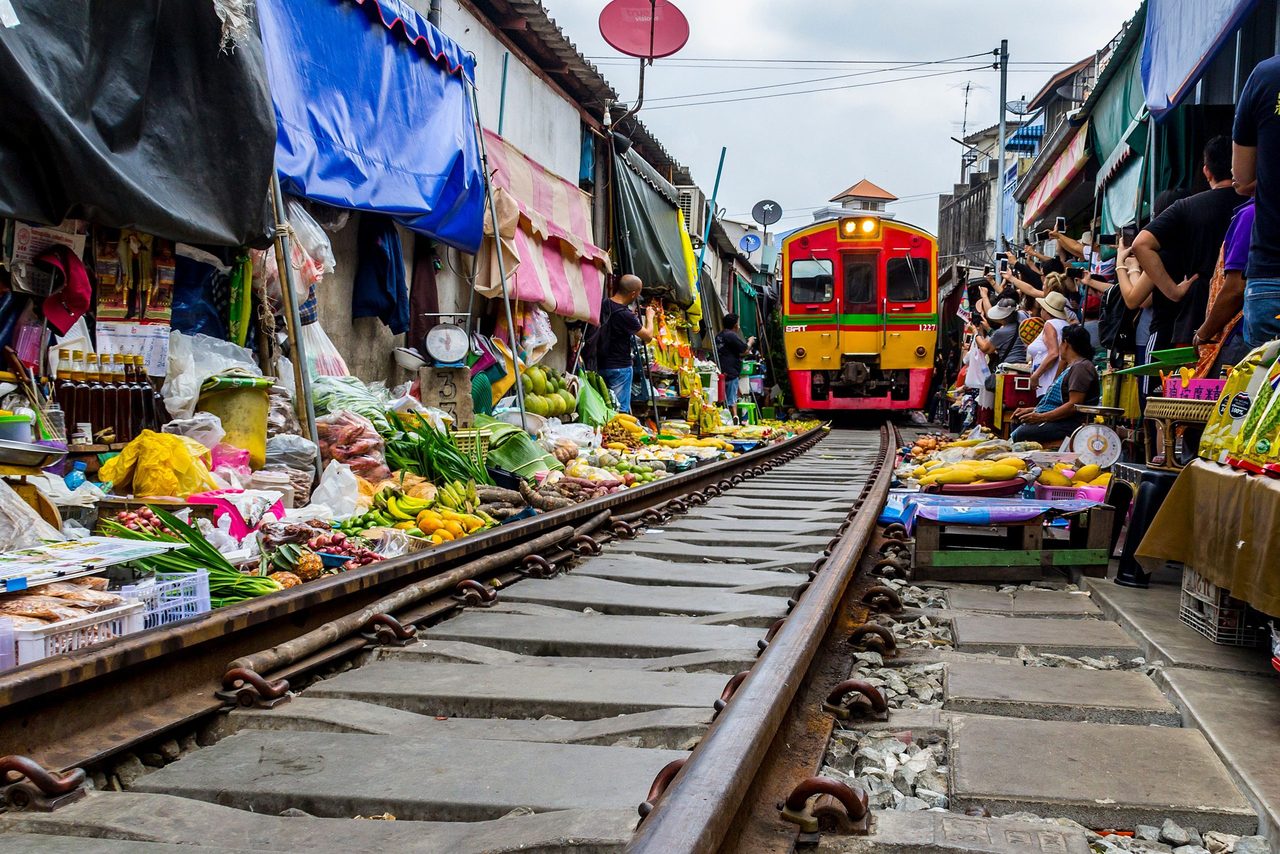 Een markt in Bangkok waar een trein doorheen rijdt.