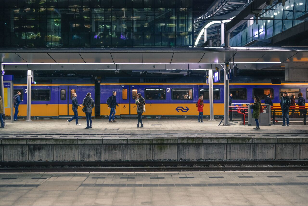 Een NS-trein met veel mensen op het perron.