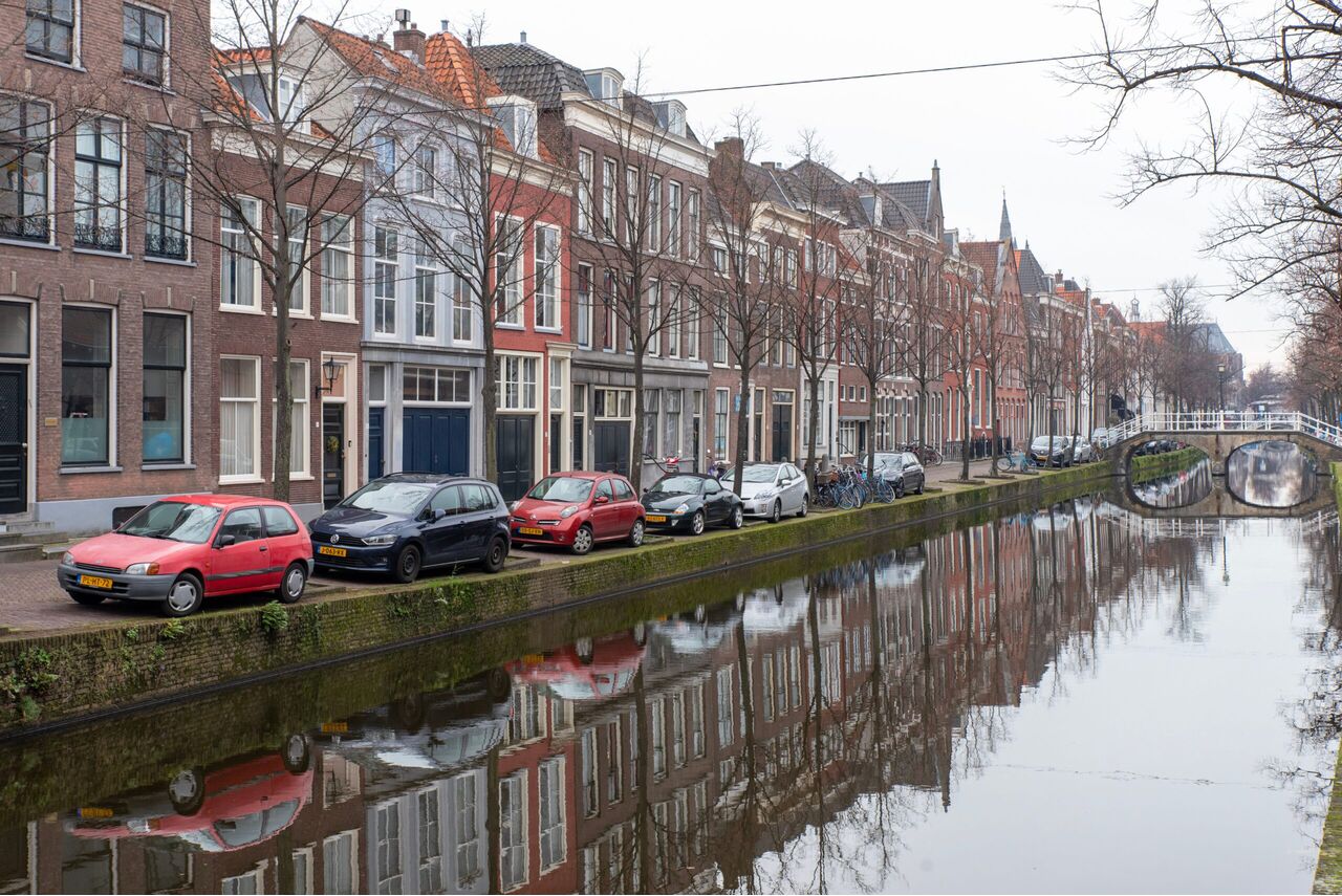 Auto's die naast de gracht geparkeerd staan.