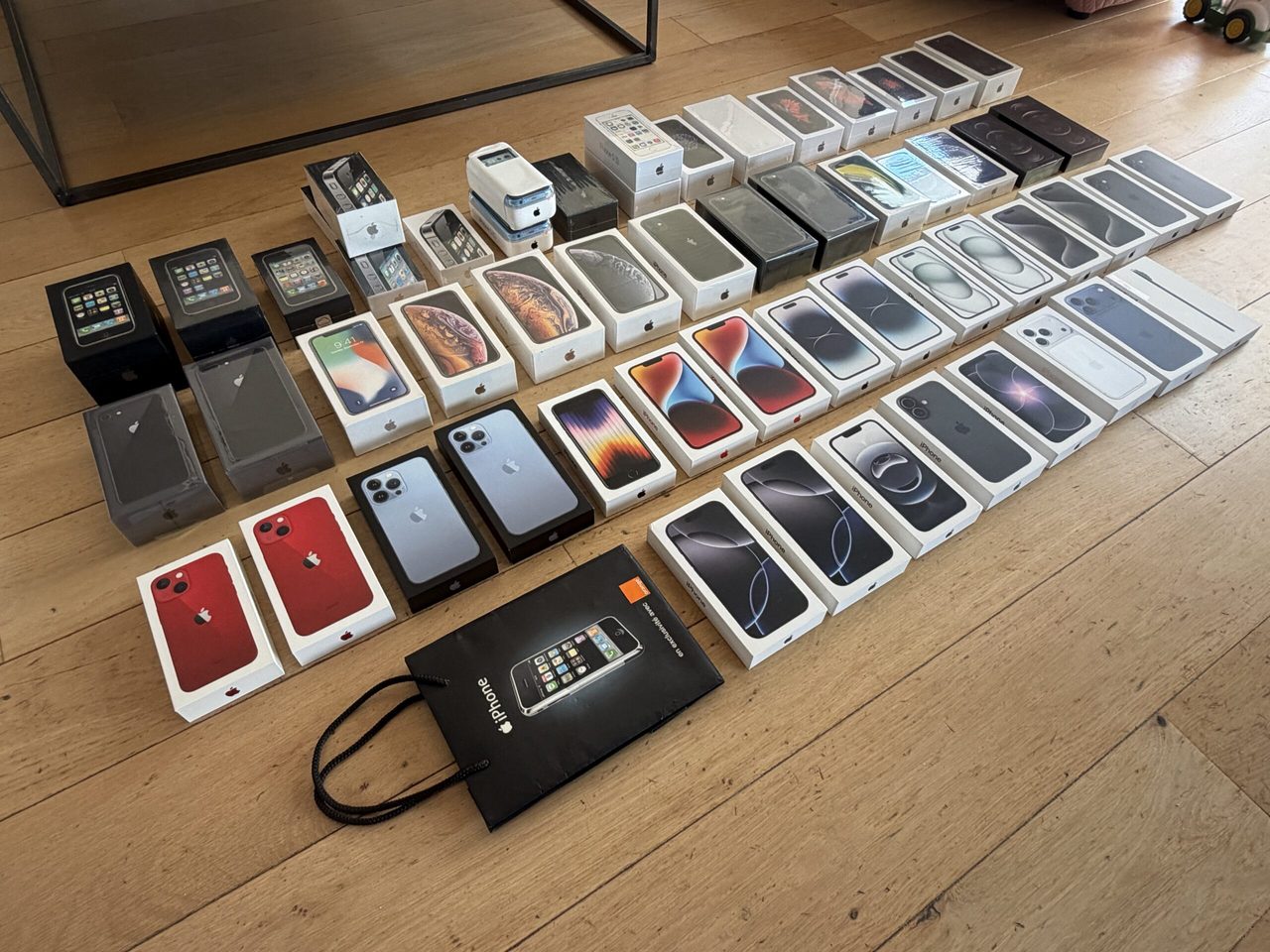 Een verzameling van 54 iphones op een tafel.