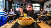 Adam, van het kanaal Beard Meats Food, tijdens zijn spaghetti eettest in België