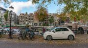 een geparkeerde auto in Amsterdam, waar de parkeerkosten stijgen