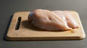 een filet van kip op een plank om te kijken of deze gezonder is dan kalkoen