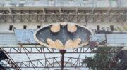 Verwoest Batman-logo boven de ingang van de verlaten nachtclub