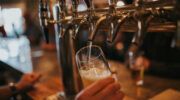 Close-up van iemand die een glas bier tapt in een kroeg