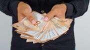 Een man die veel geld vasthoudt