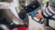 Iemand die benzine tankt aan een tankstation.