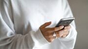 Een man die een telefoon vasthoudt, waarop hij mogelijk een NL-alert binnenkrijgt.